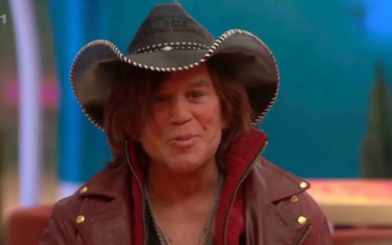 米奇·魯克（Mickey Rourke）在“名人大哥”女主持人的陪伴下在沙發上昏倒